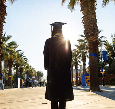 Graduate walking down the Paseo